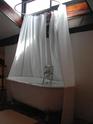 a bath tub with a shower curtain in a bathroom at Pavillon de Beauregard in Aix-en-Provence