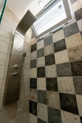 a bathroom with a shower with a tiled floor at Maison Tiki Village Aix centre in Aix-en-Provence