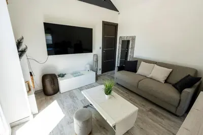 a living room with a couch and a table at Maison Tiki Village Aix centre in Aix-en-Provence