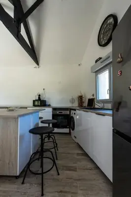 a kitchen with a counter and a stool in it at Maison Tiki Village Aix centre in Aix-en-Provence
