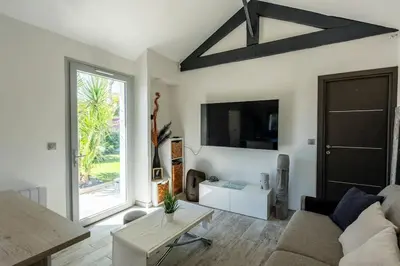 a living room with a couch and a tv at Maison Tiki Village Aix centre in Aix-en-Provence