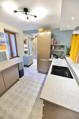 a kitchen with white counters and a refrigerator at Charmante maison de village au coeur du Luberon in Cucuron