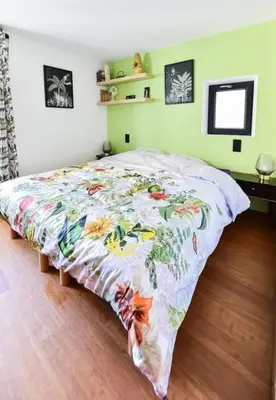 a bedroom with a bed with a floral bedspread at Charmante maison de village au coeur du Luberon in Cucuron
