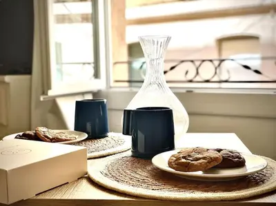 a table with two plates of cookies and a glass vase at Studio le Méditerranée in Aix-en-Provence