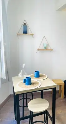 two blue cups sitting on a table with two stools at Studio le Méditerranée in Aix-en-Provence