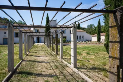 a pathway leading to a house with a pergola at Château La Croix Des Pins in Mazan