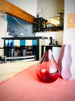 a red glass vase sitting on a red rug in a kitchen at Appartement Le Provençal in Aix-en-Provence