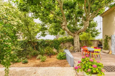 a patio with a table and chairs and trees at Mas Le Cerf in Eyragues