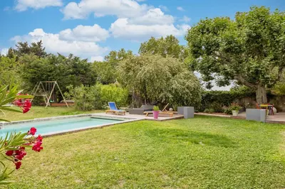 a backyard with a swimming pool and a grass yard at Mas Le Cerf in Eyragues