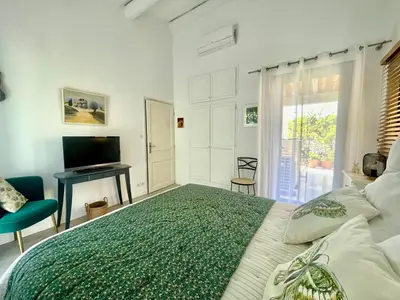a bedroom with a large bed and a television at LES CISTES in Mallemort