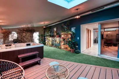 a house with a deck with a tub and a yard at La Remise en Forme in Entraigues-sur-la-Sorgue