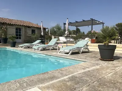 a swimming pool with lounge chairs next to a house at Chambre d'hôtes chez Maguy B-Villa Makeire in Gordes