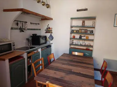 a kitchen with a wooden table and a counter top at Maison de César in Saint-Saturnin-les-Apt