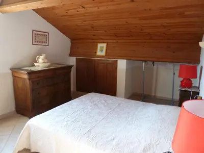 a bedroom with a white bed and wooden ceilings at Les Tournesols in Saint-Andiol
