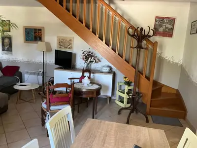 a living room with a staircase and a table and chairs at Les Tournesols in Saint-Andiol