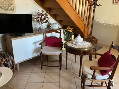 a living room with a table and chairs and a tv at Les Tournesols in Saint-Andiol
