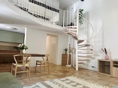 a living room with a spiral staircase and a table at LUXURY Enchanting Duplex Aix Center in Aix-en-Provence