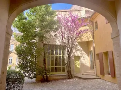 a building with an archway in front of a tree at LUXURY Enchanting Duplex Aix Center in Aix-en-Provence