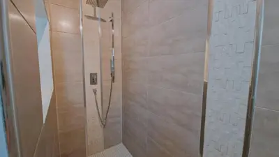 a shower in a bathroom with a tile wall at La perle du sud in Carpentras