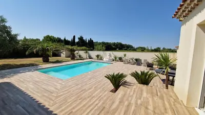 a backyard with a swimming pool and a wooden deck at La perle du sud in Carpentras
