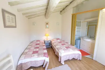 two beds in a room with a sink at mas attached to another building with private pool 4 people in carpentras, at the foot of the ventoux in provence. in Carpentras
