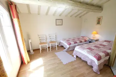 a bedroom with two beds and a table and chairs at mas attached to another building with private pool 4 people in carpentras, at the foot of the ventoux in provence. in Carpentras