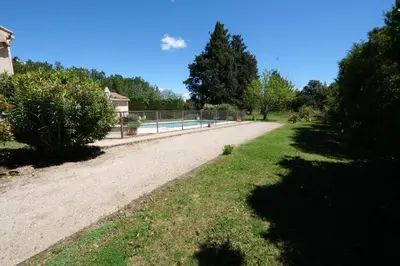 a dirt road with a fence next to a pool at mas attached to another building with private pool 4 people in carpentras, at the foot of the ventoux in provence. in Carpentras