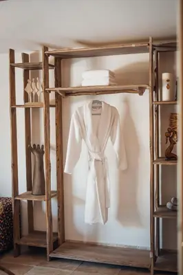 a wooden shelf with a white robe hanging on it at Le Domaine du Printemps in Monteux
