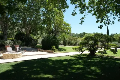 a park with a bench and trees and grass at magnificient property with heated swimming-pool in the luberon - 14 persons in Les Taillades
