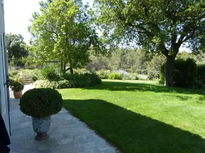 a yard with a lawn with a vase in the shade at Lou Pantai, Bed and Breakfast, Delux Bedroom with AC in Aix-en-Provence