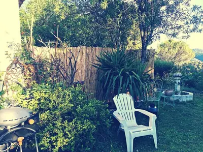 a yard with two white chairs and a fence at Entre Ventoux et Luberon, appartement dans maison. in Malemort-du-Comtat
