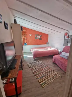 a living room with a bed and a tv at Entre Ventoux et Luberon, appartement dans maison. in Malemort-du-Comtat