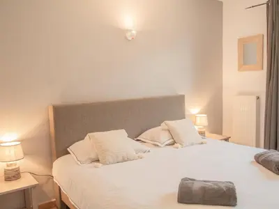 a bed with two pillows on it with two night stands at La Roque in La Roque-sur-Pernes