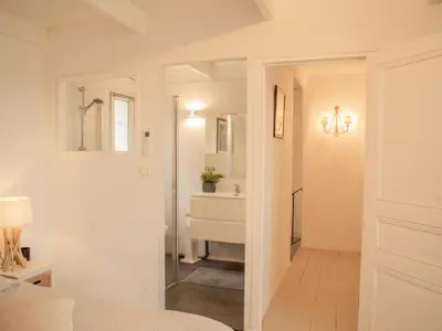 a white bathroom with a sink and a mirror at La Roque in La Roque-sur-Pernes