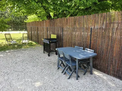 a blue table and chairs next to a fence at Petite maison en campagne in Pernes-les-Fontaines