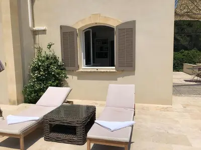 a villa with a swimming pool and palm trees at Appartement dans bastide à Saint Rémy de Provence in Saint-Rémy-de-Provence