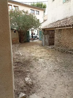 an empty yard with a tree and a building at Maison de village avec exterieur in Lambesc