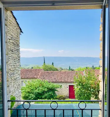 a view from a window of a building with a red door at Cigale de Gordes in Gordes