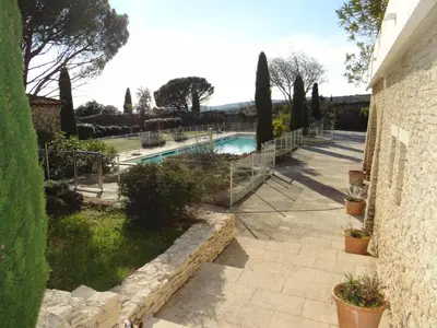 a swimming pool in a garden with trees and bushes at Cigale de Gordes in Gordes