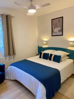 a bedroom with a large bed with blue and white pillows at Cigale de Gordes in Gordes