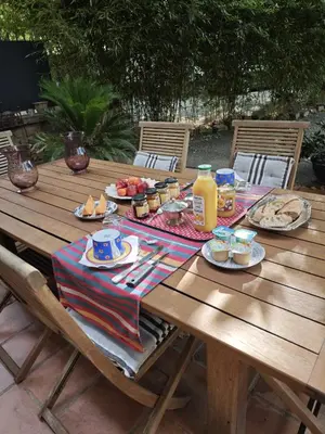 a wooden picnic table with food and drinks on it at Le mas de l'Auzon in Carpentras