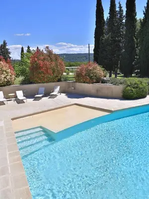 a swimming pool with two lounge chairs at Domaine la Carraire in Lauris