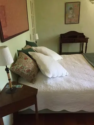 a bedroom with a bed with pillows and a table at Domaine la Carraire in Lauris