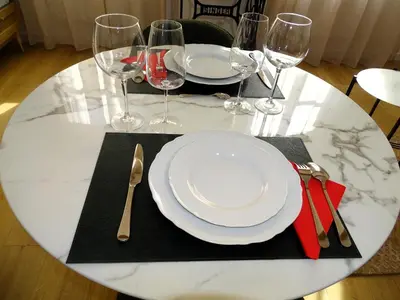 a table with a white plate and wine glasses at AUGUSTINS FOUNTAIN Studio Cosy AIX Centre Historique à 3 minutes de COURS MIRABEAU -WIFI-SMART TV-RUE CALME in Aix-en-Provence