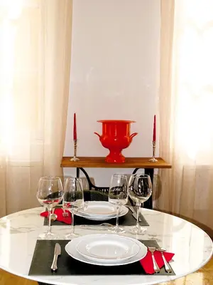 a table with a plate and wine glasses on it at AUGUSTINS FOUNTAIN Studio Cosy AIX Centre Historique à 3 minutes de COURS MIRABEAU -WIFI-SMART TV-RUE CALME in Aix-en-Provence