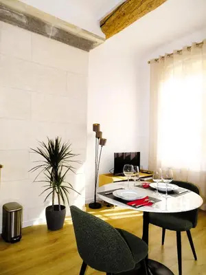 a dining room with a table and two chairs at AUGUSTINS FOUNTAIN Studio Cosy AIX Centre Historique à 3 minutes de COURS MIRABEAU -WIFI-SMART TV-RUE CALME in Aix-en-Provence