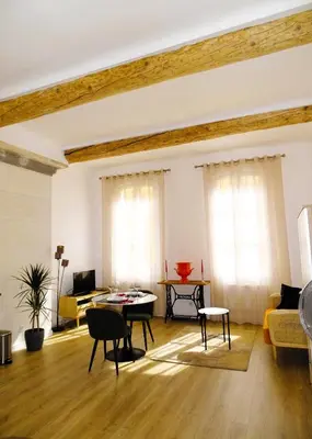 a living room with a couch and a table at AUGUSTINS FOUNTAIN Studio Cosy AIX Centre Historique à 3 minutes de COURS MIRABEAU -WIFI-SMART TV-RUE CALME in Aix-en-Provence