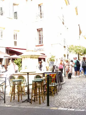 an outdoor cafe with chairs and tables and people at AUGUSTINS FOUNTAIN Studio Cosy AIX Centre Historique à 3 minutes de COURS MIRABEAU -WIFI-SMART TV-RUE CALME in Aix-en-Provence