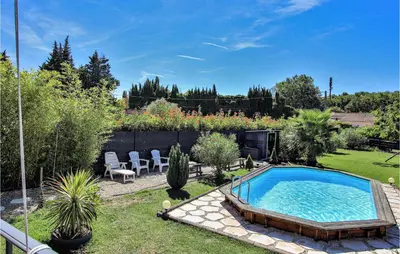 a backyard with a swimming pool in the grass at Gorgeous Home In Aubignan in Aubignan