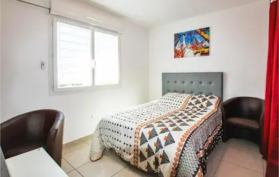 a bedroom with a bed with two chairs and a window at Gorgeous Home In Aubignan in Aubignan